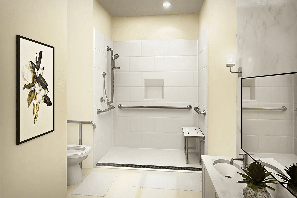 Accessible bathroom with a curbless roll-in shower, horizontal and vertical grab bars, a fold-down shower seat, and a handheld shower on a slide bar